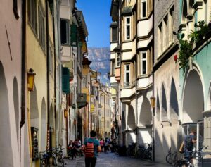 Veduta del centro storico di Merano con un turista che passeggia